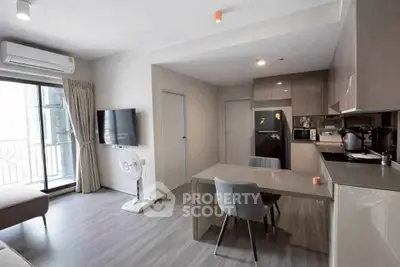 Modern open-plan living room with sleek kitchen and balcony access in a stylish apartment.