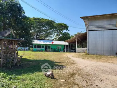 Spacious rural property with large warehouse and green building, ideal for storage or business use.