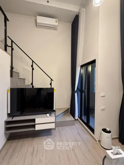 Modern loft-style living room with high ceiling and large windows