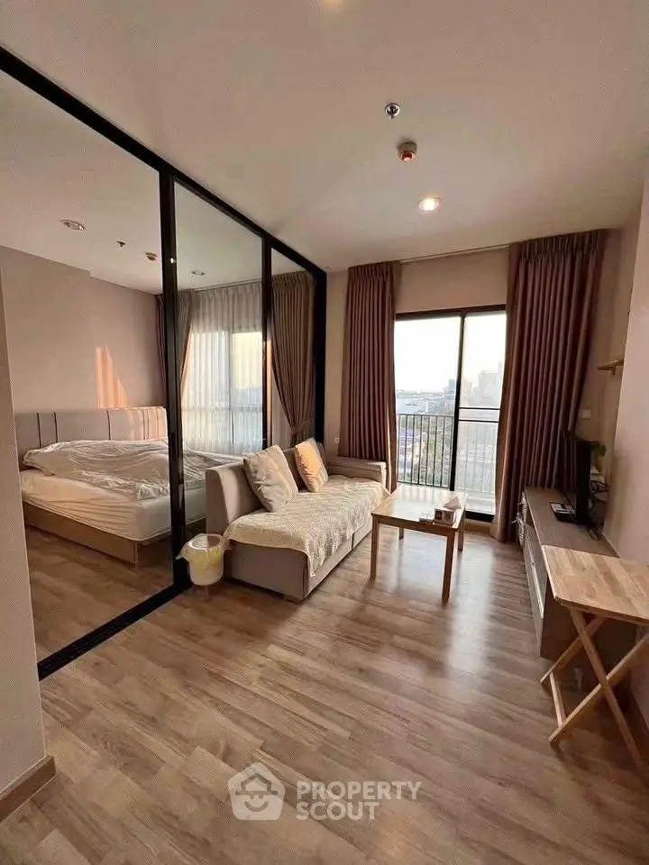 Modern studio apartment with glass partition, cozy living area, and city view balcony.