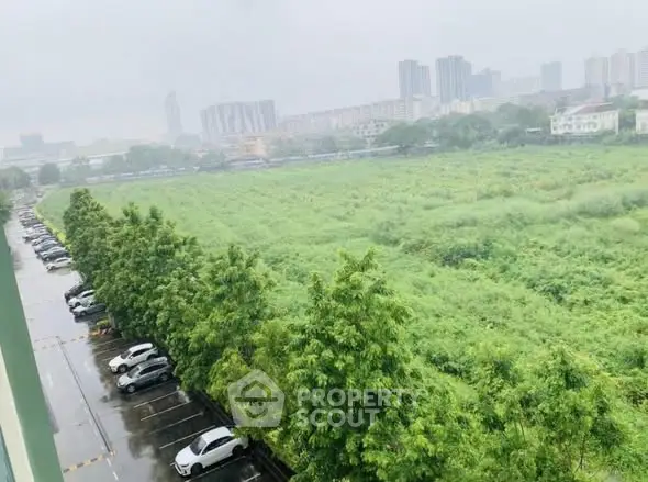 Expansive green field view with city skyline in the background, ideal for development.
