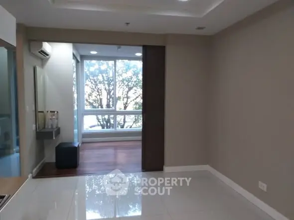 Spacious modern living room with large window and natural light