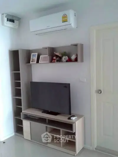Modern living room with sleek TV stand and wall-mounted air conditioner, perfect for comfortable living.