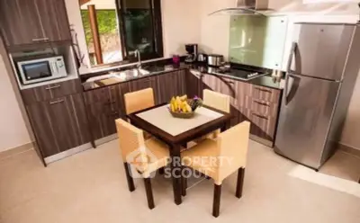Modern kitchen with sleek cabinets, stainless steel appliances, and cozy dining area.