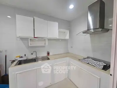 Modern kitchen with sleek white cabinets and stainless steel range hood