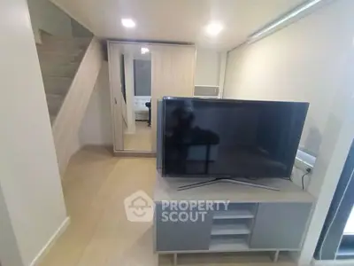 Modern living room with sleek TV stand and mirrored wardrobe, featuring minimalist design and neutral tones.