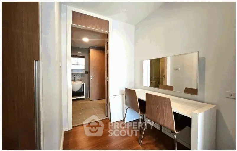 Modern study area with sleek wooden furniture and large mirror