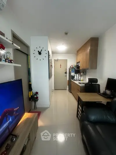 Modern living room with sleek kitchen, stylish decor, and cozy seating area in a compact apartment.