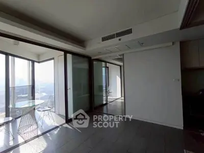 Spacious modern apartment with floor-to-ceiling windows and stunning city views.