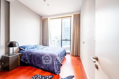 Modern bedroom with city view, featuring sleek design and natural light.