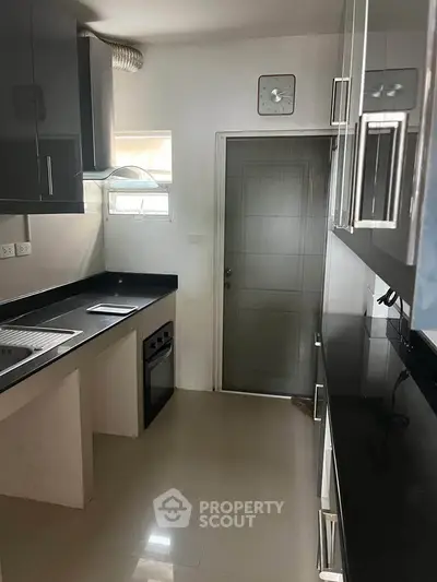 Modern kitchen with sleek black countertops and stainless steel appliances