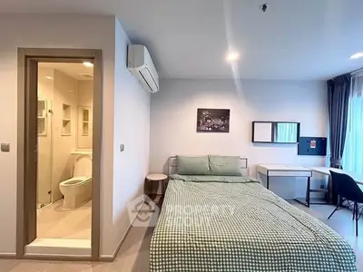 Modern bedroom with ensuite bathroom, featuring a cozy bed, study desk, and air conditioning.
