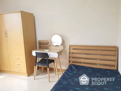 Bright and airy bedroom with a comfortable double bed, sleek wooden headboard, matching wardrobe, and a charming vanity table with a round mirror.