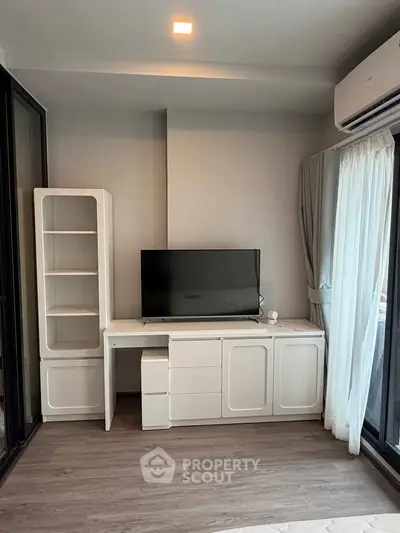 Modern living room with sleek TV stand and large window for natural light