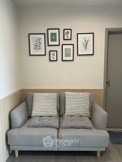 Cozy living room with stylish gray sofa and framed botanical art