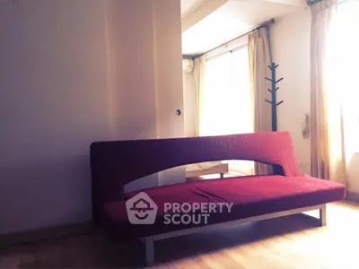 Spacious living room with modern red sofa and natural light