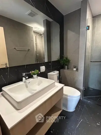 Modern bathroom with sleek fixtures and elegant design, featuring a spacious shower and stylish vanity.