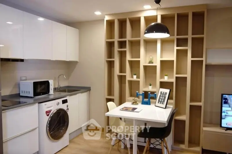 Modern kitchen with washing machine and dining area in stylish apartment