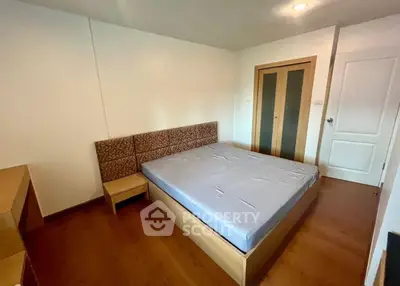 Spacious bedroom with wooden flooring and modern design