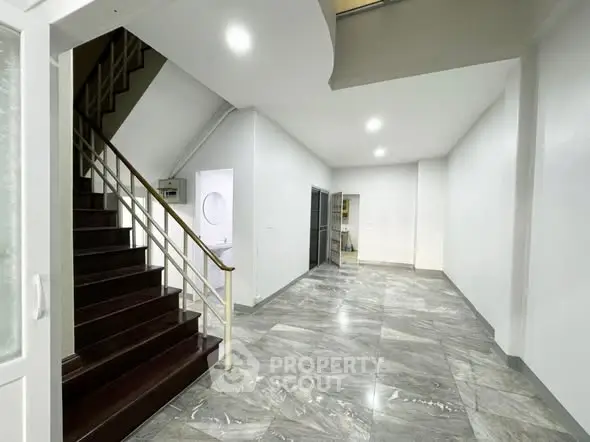 Spacious modern interior with marble flooring and elegant staircase.