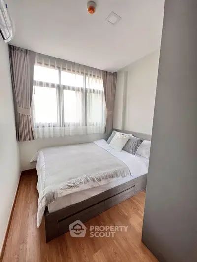 Cozy bedroom with natural light and modern decor, featuring a comfortable bed and elegant curtains.