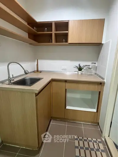 Modern compact kitchen with wooden cabinets and sleek countertops, perfect for efficient cooking.