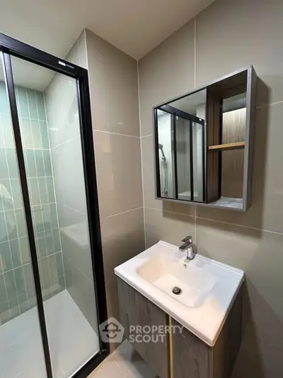 Modern bathroom with sleek design featuring a glass shower and stylish vanity.