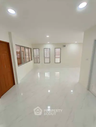 Spacious and bright living room with modern marble flooring and ample natural light.