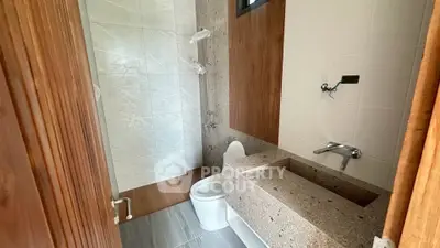 Modern bathroom with sleek design featuring a stone countertop and elegant shower area.