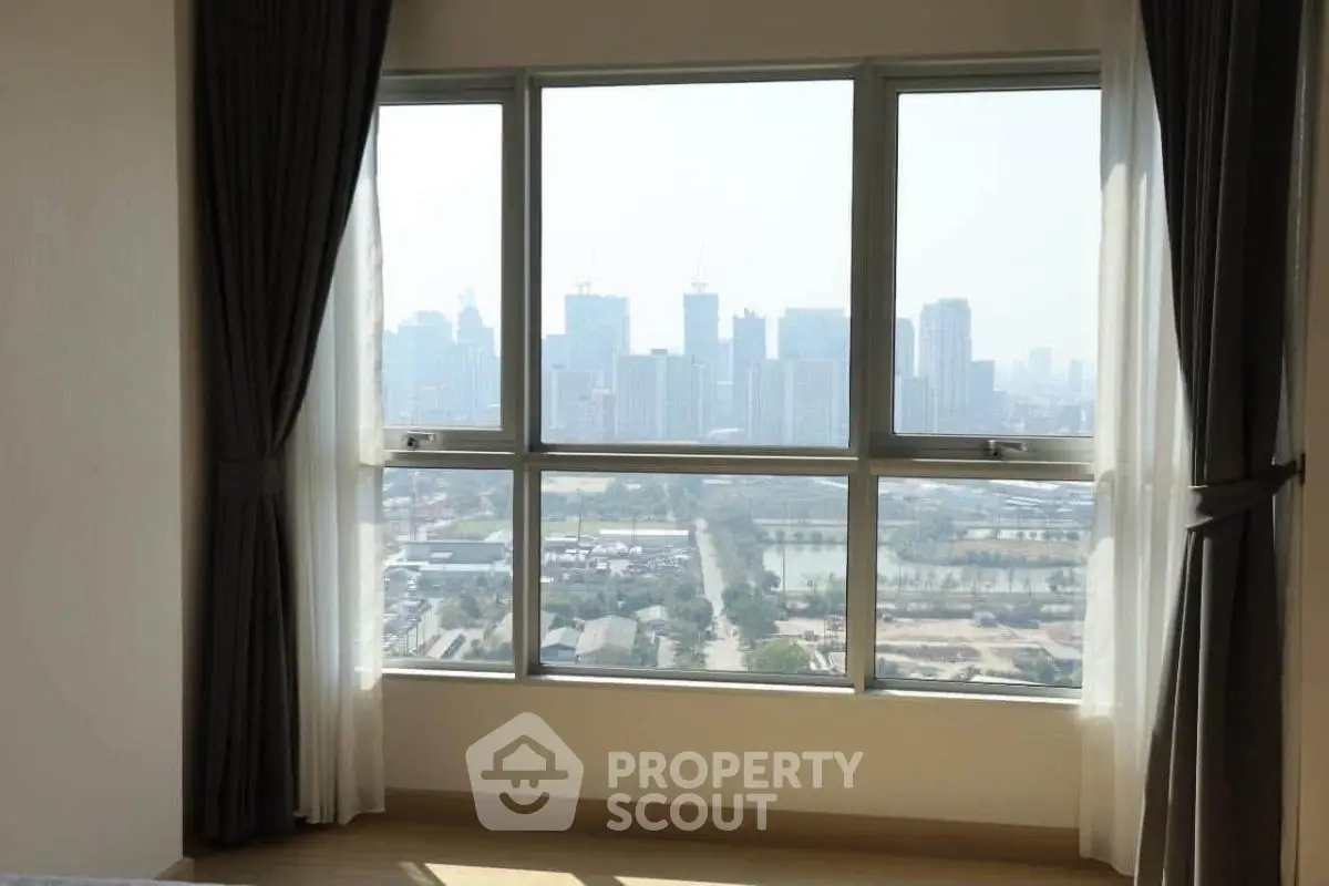 Spacious apartment with stunning city skyline view through large windows.