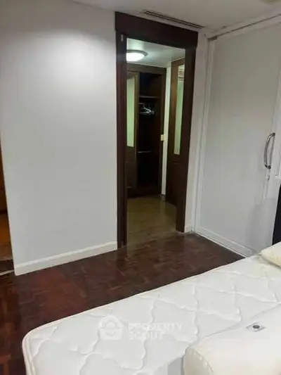 Spacious bedroom with walk-in closet and wooden flooring