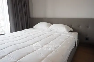 Modern bedroom with plush bed and city view, perfect for urban living.