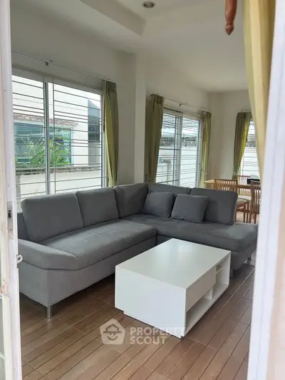 Spacious living room with modern gray sectional sofa and large windows