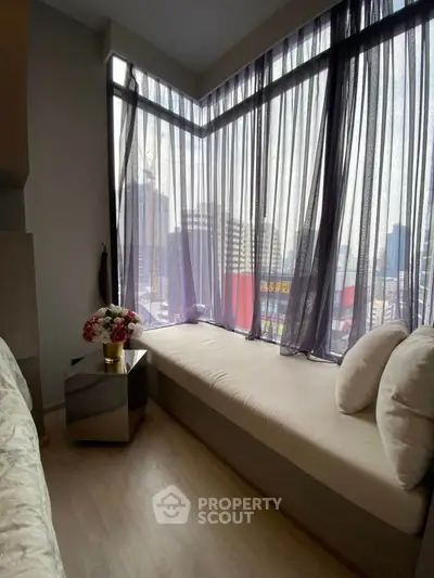 Cozy corner unit with panoramic city view from large windows and elegant decor.
