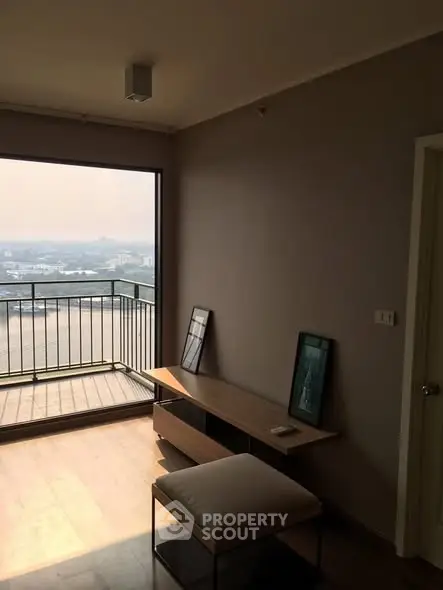 Modern living room with large window and balcony offering stunning city view
