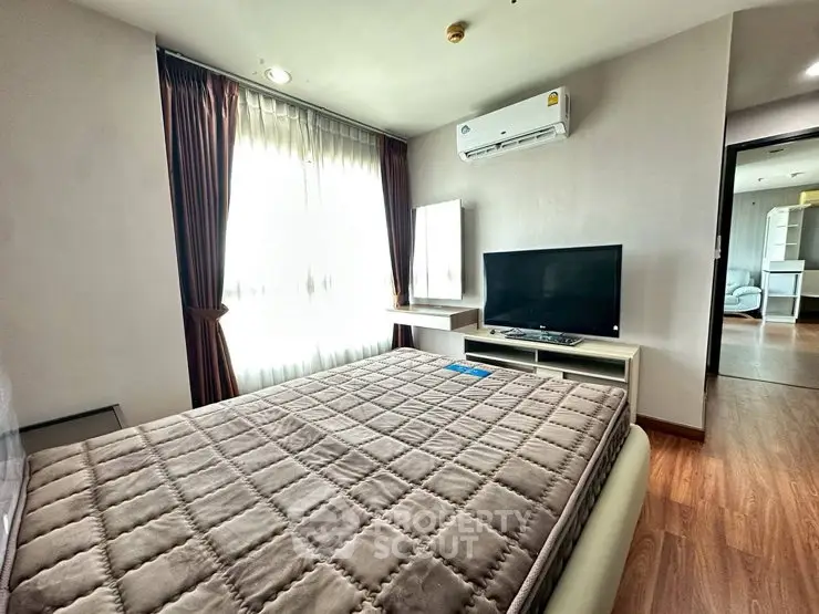 Spacious bedroom with modern furnishings and natural light in a stylish apartment.