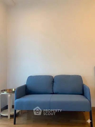 Cozy living room with stylish blue sofa and side table, perfect for modern interiors.