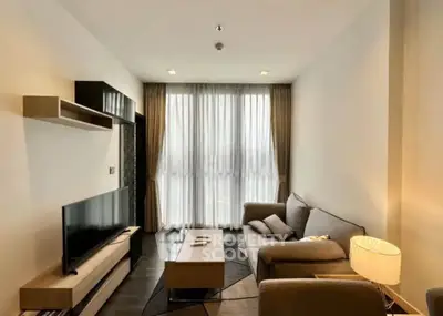 Modern living room with cozy sofa, large TV, and elegant decor in a bright apartment.