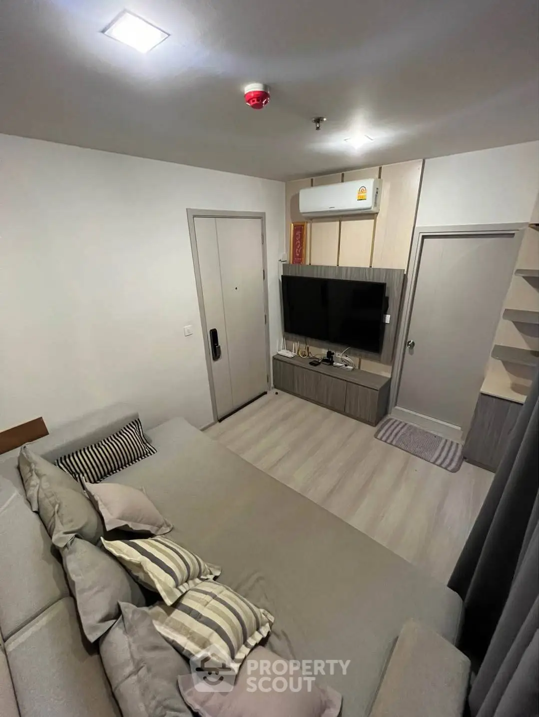 Modern living room with cozy sofa and wall-mounted TV in a stylish apartment.