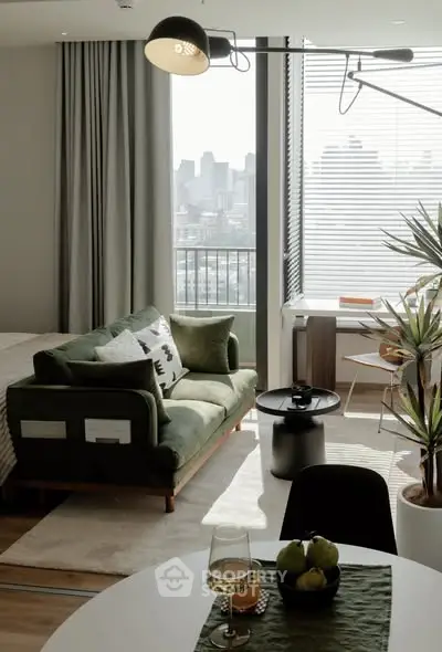 Stylish modern living room with city view, green sofa, and elegant decor.