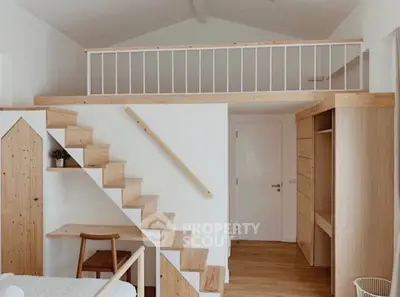 Charming loft-style bedroom with wooden staircase and minimalist design