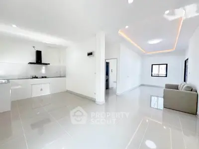 Spacious modern living room with open kitchen and sleek tile flooring