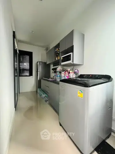 Modern kitchen with sleek appliances and ample storage in a compact layout.