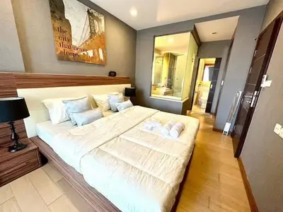 Luxurious bedroom with ensuite bathroom and modern decor in upscale apartment.