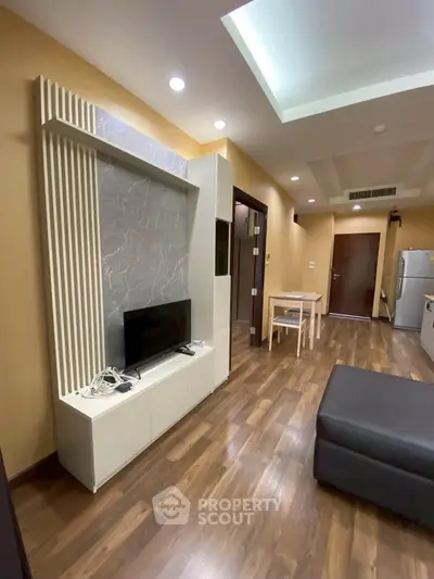 Modern living room with stylish decor and open layout, featuring wooden flooring and sleek furniture.