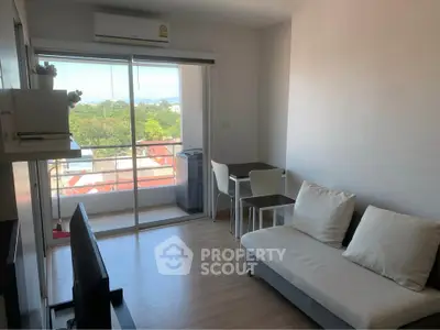 Bright living room with balcony view, modern furnishings, and natural light.