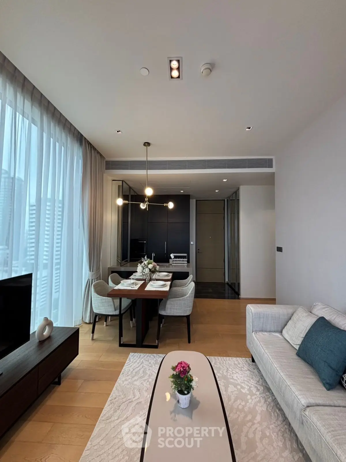 Modern living room with elegant dining area and large windows in a high-rise apartment.