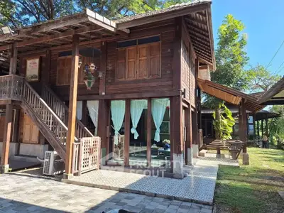 Charming wooden house with large windows and lush garden, perfect for serene living.
