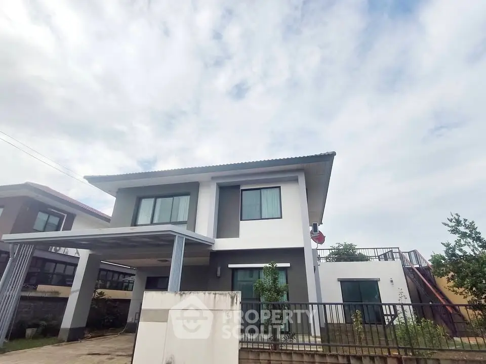 Modern two-story house with sleek design and spacious driveway under a cloudy sky.