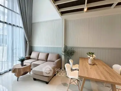 Modern living room with high ceilings, elegant decor, and natural light.